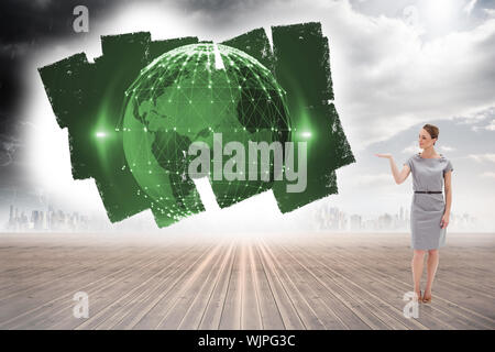 Woman in a dress holding her hand up against screen showing earth graphic Stock Photo