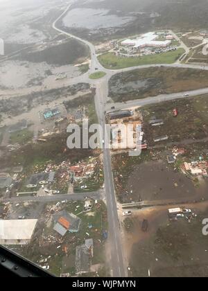Marsh Harbour, Abaco, Bahamas. 03 September, 2019. A U.S. Coast Guard Jayhawk rescue helicopter surveys the destruction from the air as it approaches to land to assist in the aftermath of Hurricane Dorian September 3, 2019 in Marsh Harbour, Abaco, Bahamas. Dorian struck the small island nation as a Category 5 storm with winds of 185 mph.  Credit: Hunter Medley/USCG/Alamy Live News Stock Photo