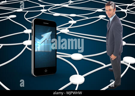 Cheerful businessman standing with hands on hips against shiny lines on black background Stock Photo