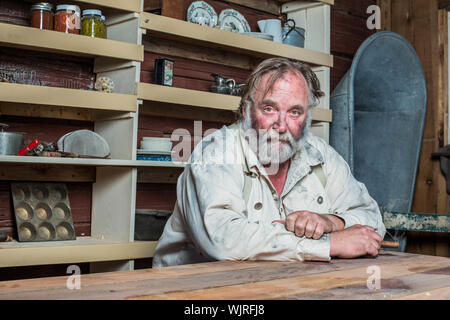 Solemn western man looks towards you as he sits at table Stock Photo