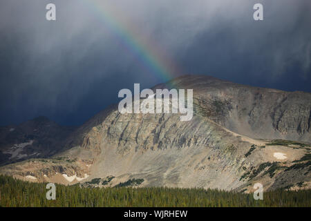 Stormy rainbow over the Rocky Mountains Stock Photo