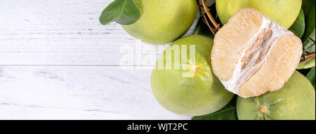 Fresh peeled pomelo, grapefruit, shaddock with green leaf on bright wooden plank table. Seasonal fruit near mid-autumn festival, top view, copy space Stock Photo