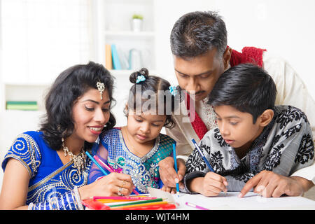 Asian Indian family drawing and painting picture at home. India family lifestyle. Happy parents and children having fun. Stock Photo