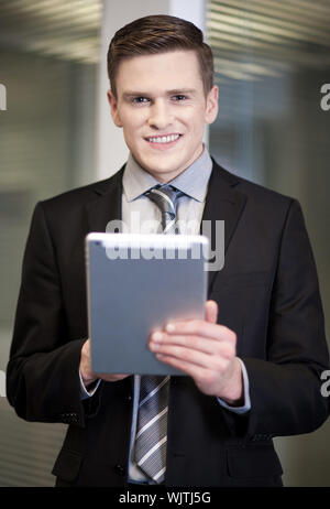 Corporate guy using tablet pc at workplace Stock Photo