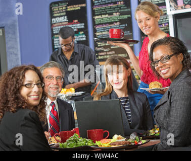 Happy group of people with laptop in cafe and barista Stock Photo