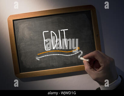 Hand writing the word edit on black chalkboard Stock Photo