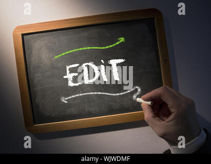 Hand writing the word edit on black chalkboard Stock Photo