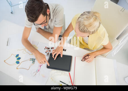 Overhead view of two fashion designers using digital laptop in a studio Stock Photo