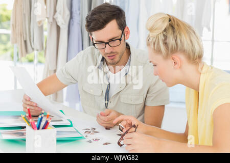 Two fashion designers discussing designs in a studio Stock Photo