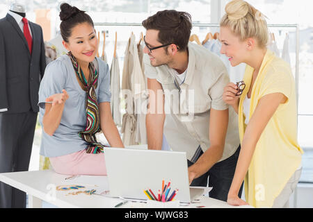 Three fashion designers using laptop in a studio Stock Photo