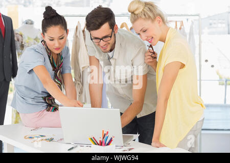 Three fashion designers using laptop in a studio Stock Photo