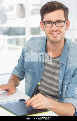 Casual male photo editor using graphics tablet in a bright office Stock Photo