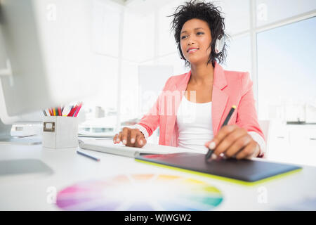 Casual female photo editor using graphics tablet in a bright office Stock Photo