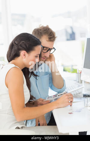 Team of designers working together at desk in creative office Stock Photo