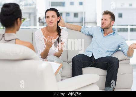 Angry couple talking to their therapist in therapists office Stock Photo