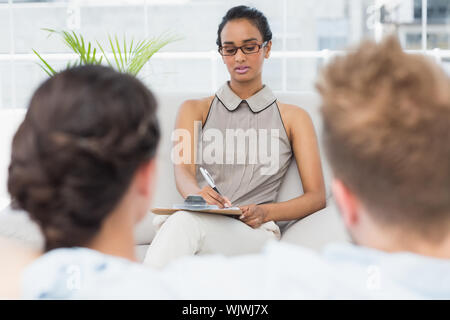 Therapist talking with couple on the couch in therapists office Stock Photo