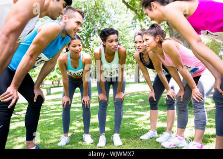 Group of marathon runners discussing before a race in the park Stock Photo