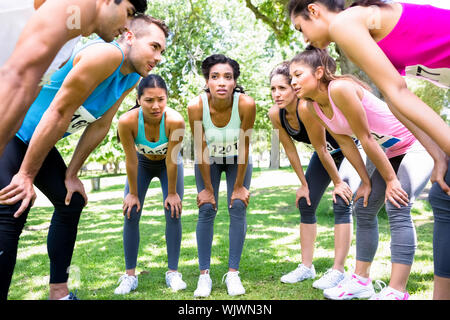 Group of marathon runners discussing before a race in the park Stock Photo