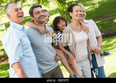 Side view of a cheerful extended family standing at the park Stock Photo