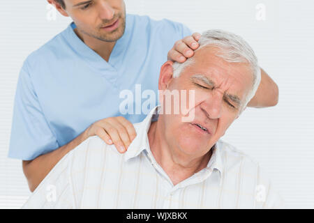 Male chiropractor doing neck adjustment in the medical office Stock Photo