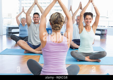 Sporty people with joined hands over heads at fitness studio Stock Photo