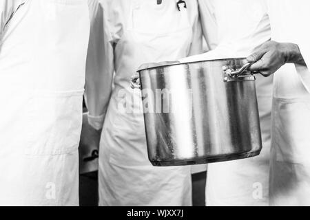 Cook with big cooking pot in the kitchen Stock Photo - Alamy