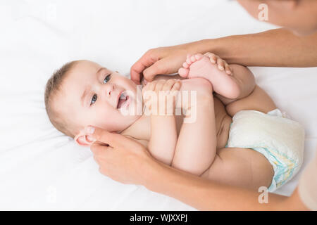 High angle view of baby boy receiving massage from mother in bed