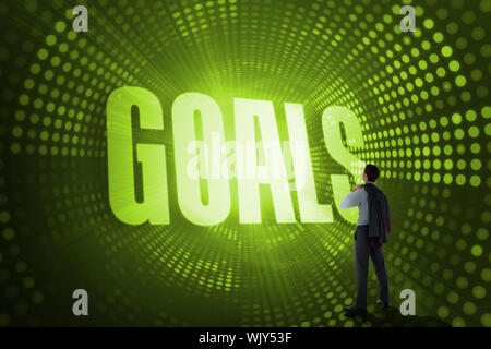 The word goals and businessman holding his jacket against green pixel spiral Stock Photo