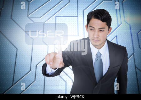 The word user and unsmiling asian businessman pointing against circuit board on futuristic background Stock Photo