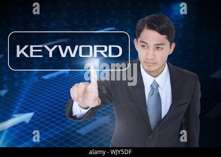 The word keyword and unsmiling asian businessman pointing against grid and arrows on black background Stock Photo