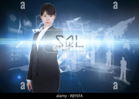 The word sql and focused businesswoman pointing against glowing technological background Stock Photo