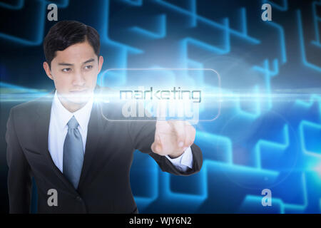 The word marketing and unsmiling asian businessman pointing against shiny lines on black background Stock Photo