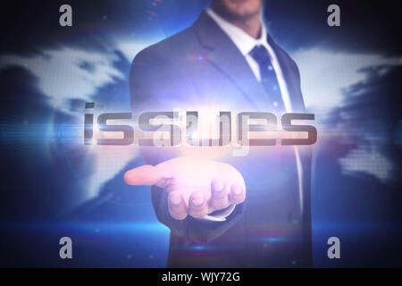 The word issues and businessman presenting against glowing world map on black background Stock Photo