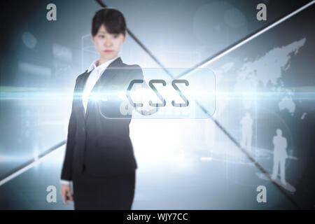 The word css and focused businesswoman pointing against futuristic screen with lines Stock Photo