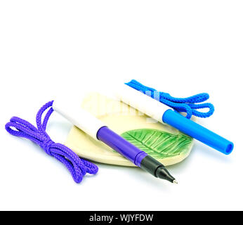 Beautiful purple and blue ballpoint pen, isolated on a white background with a saucer Stock Photo