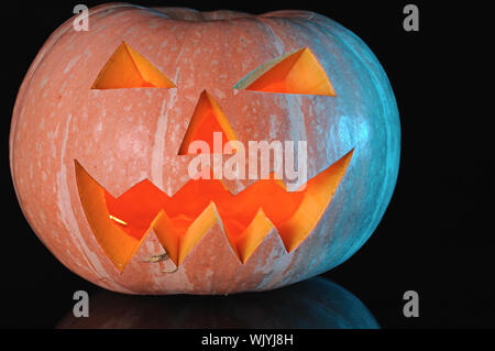 pumpkin with lighting candle inside on black background Stock Photo