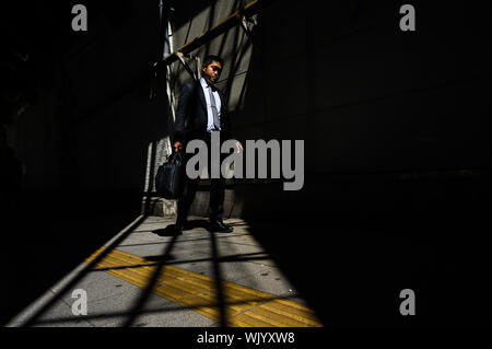 Salaryman walking in the shadows, Marunouchi, Tokyo, Japan Stock Photo