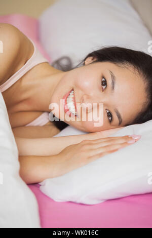 Pretty young asian woman lying in her bed smiling Stock Photo