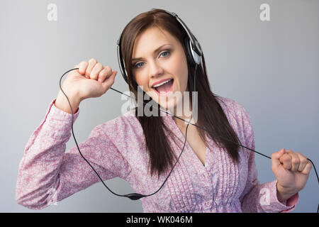 Cheerful young brunette listening to music Stock Photo