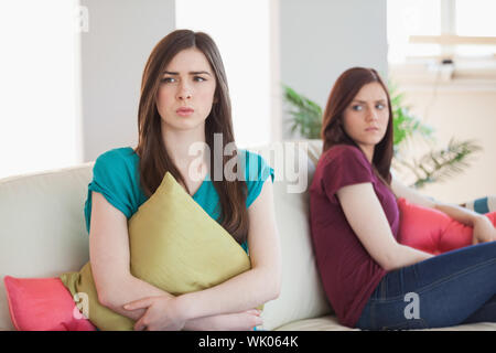 Two upset friends not talking to each other after fight on the sofa Stock Photo