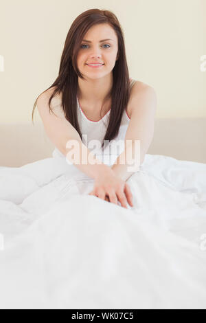 Awakened girl sitting in her bed looking Stock Photo