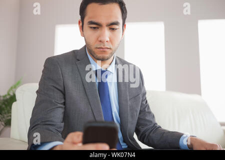 Serious businessman sending a text message Stock Photo