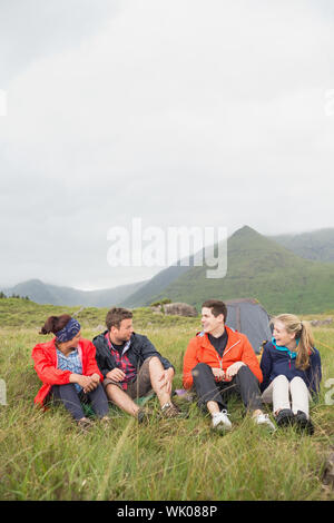 Friends talking together on a camping trip Stock Photo