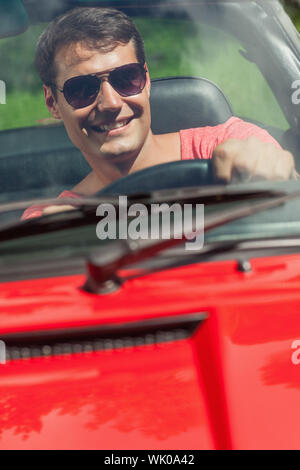Cheerful handsome man driving his cabriolet Stock Photo