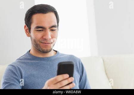 Smiling casual man text messaging Stock Photo