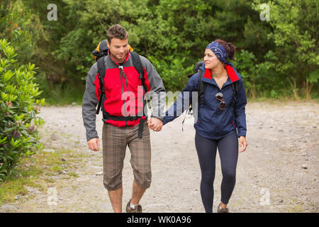 Smiling couple going on a hike together holding hands Stock Photo