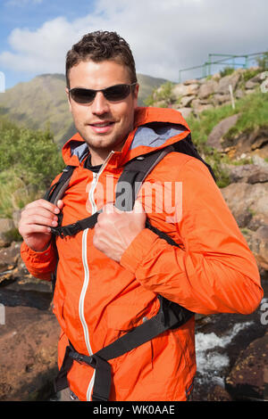 Man wearing rain jacket and sunglasses smiling at camera Stock Photo