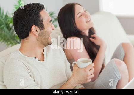 Cheerful couple relaxing together on sofa Stock Photo