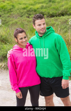Athletic couple looking ahead and embracing Stock Photo