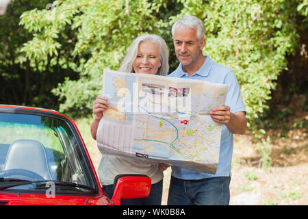 Smiling mature couple reading map Stock Photo